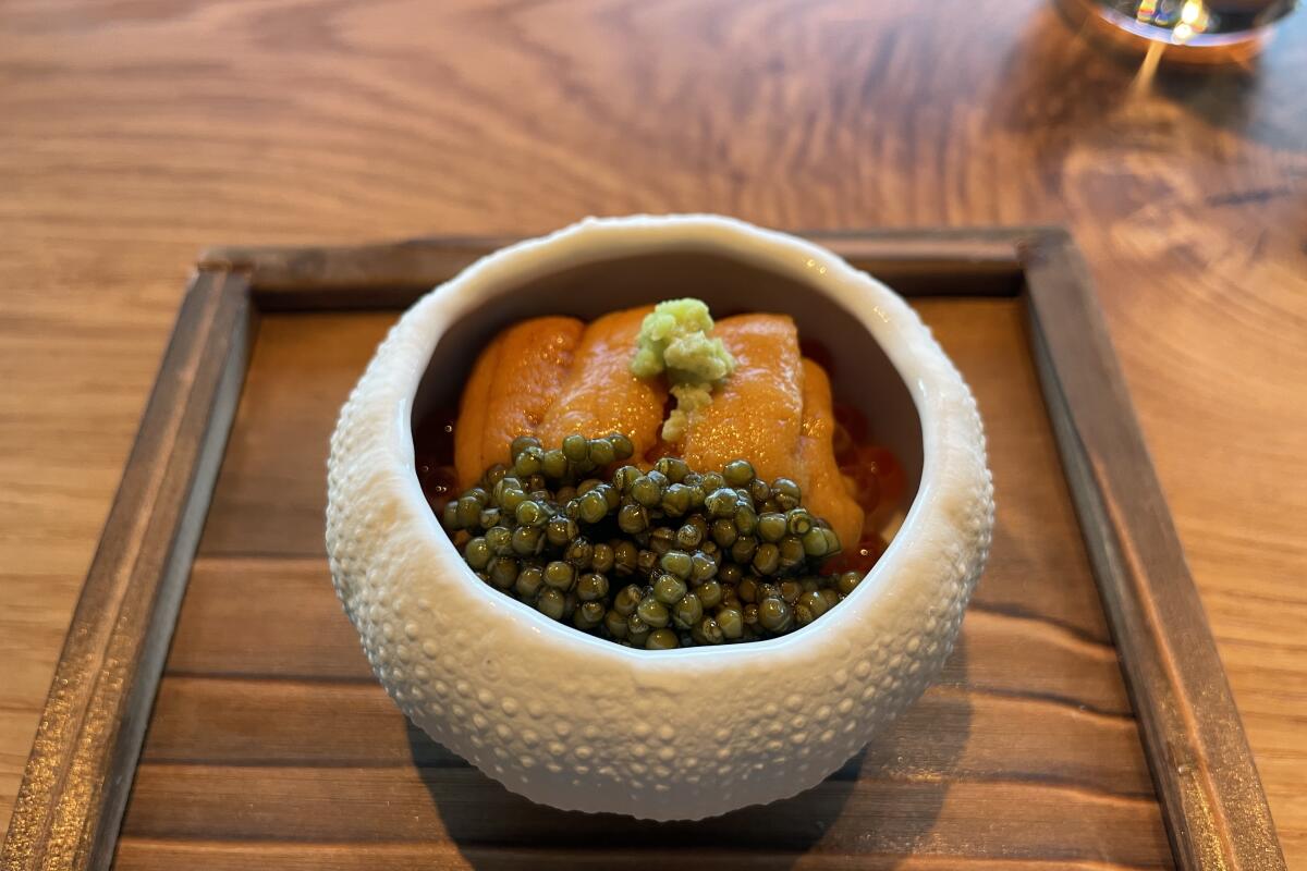 A white bowl shaped like a sea urchin with uni, caviar and wasabi