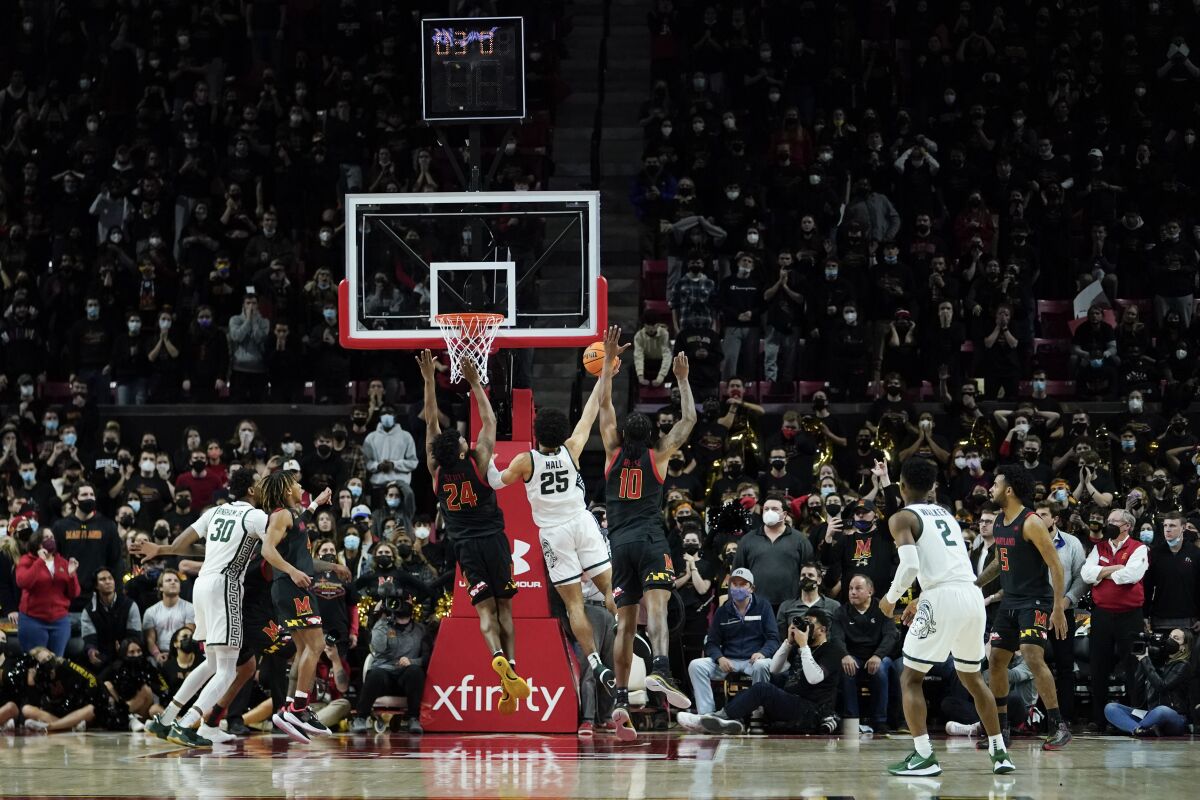 Michigan State forward Malik Hall (25) scores the eventual game-winning basket against Maryland forward Donta Scott (24) and forward Julian Reese (10) with less than two seconds left in the second half of an NCAA college basketball game, Tuesday, Feb. 1, 2022, in College Park, Md. Michigan State won 65-63. (AP Photo/Julio Cortez)