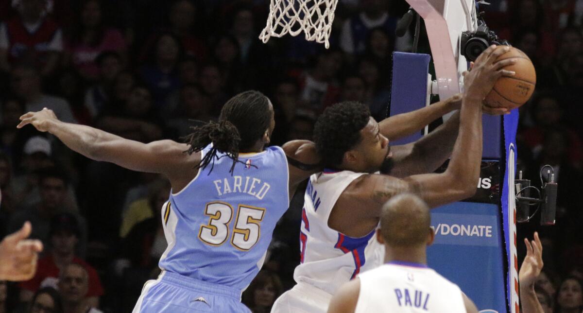 Clippers center DeAndre Jordan and Nuggets power forward Kenneth Faried battle for a rebound in the first half.