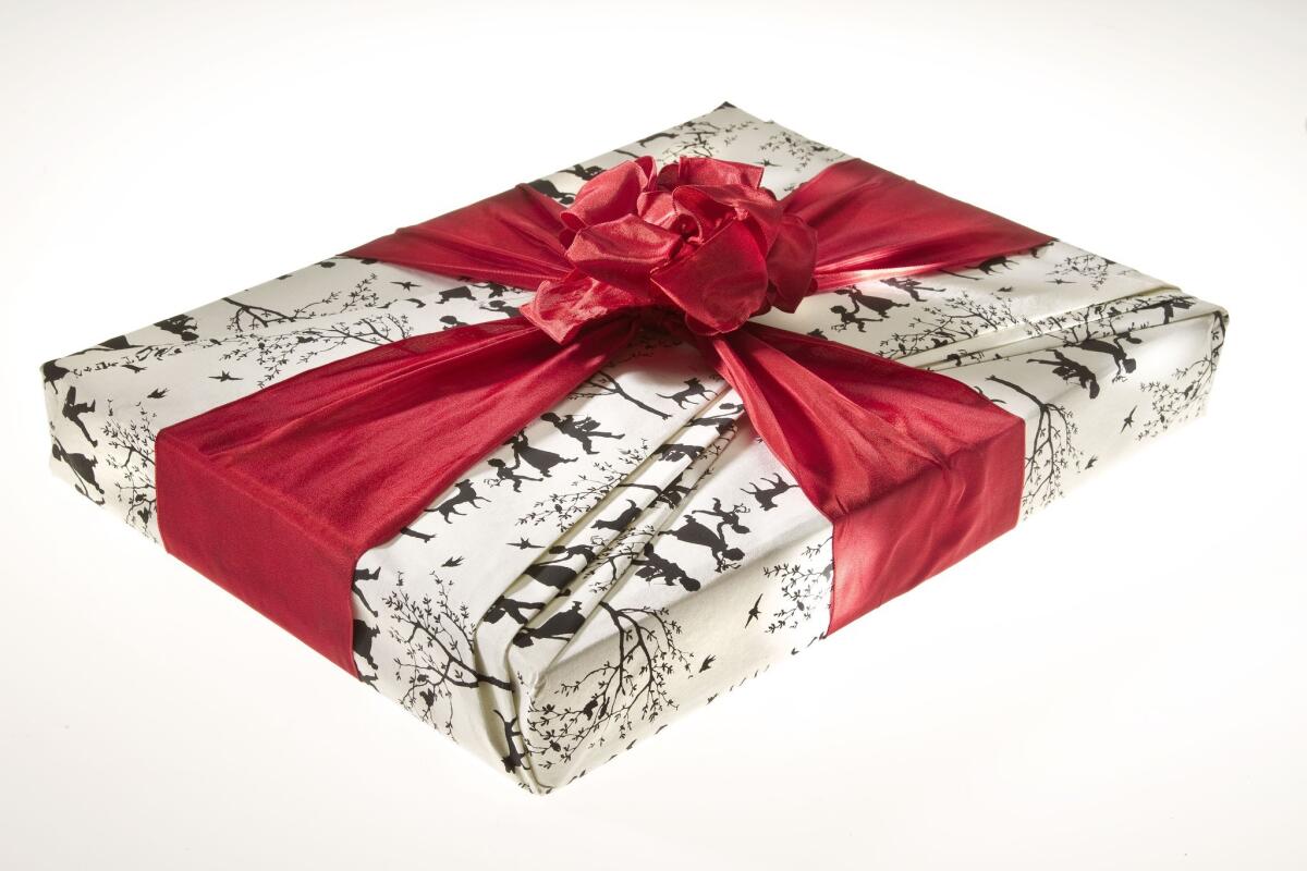 a gift-wrapped book with a red ribbon and bow