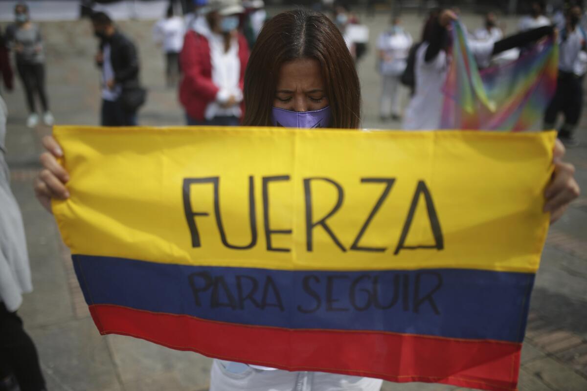 Woman holding Colombian flag and praying