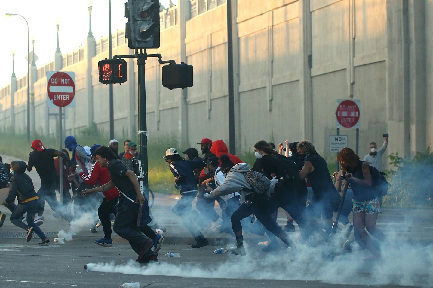 People run as tear gas canisters land near them.
