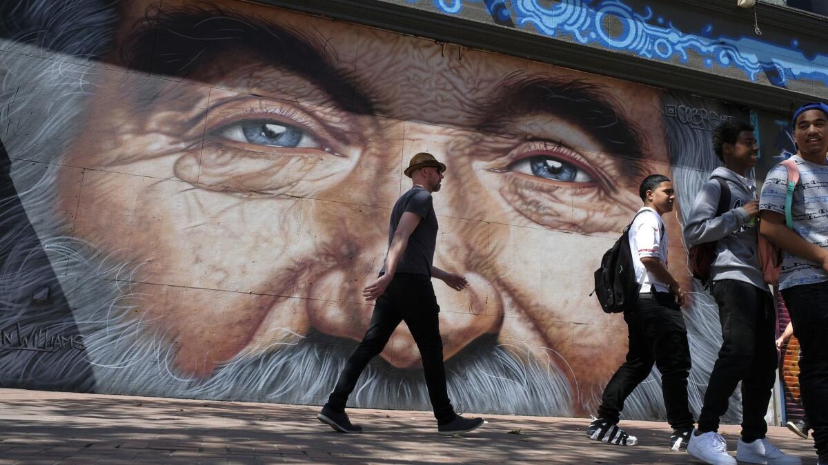 People walk past a mural of Robin Williams on Market Street in San Francisco.