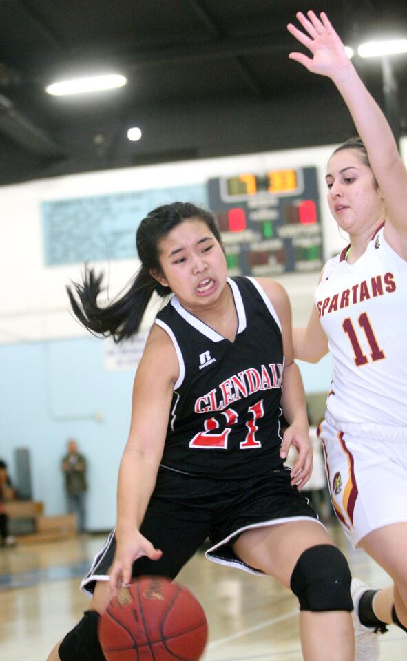 Glendale High's Claire Yanai drives to the basket in a game against La Cañada High's Kristina Kurdoghlian at Arroyo High School in El Monte on Friday, Dec. 18, 2015.