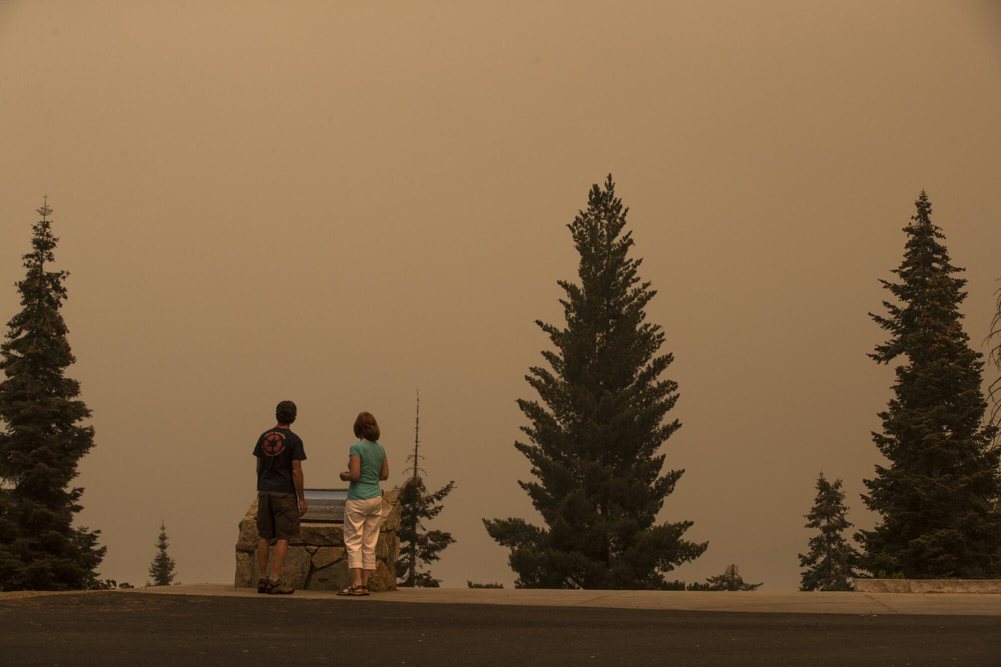Greg and Dana Farr stand at Kings Canyon Overlook, which is shrouded in smoke