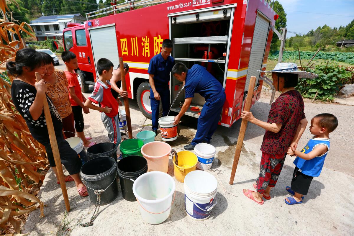  Villagers carry water home in Suining City, Southwest China's Sichuan Province, Aug 23, 2022. 