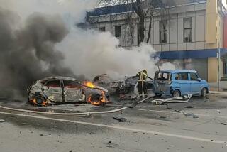 In this photo taken from video released by Russia Emergency Situations Ministry telegram channel on Saturday, Dec. 30, 2023, firefighters extinguish burning cars after shelling in Belgorod, Russia. Russian officials have accused Ukrainian forces of shelling the Russian border city of Belgorod. Two children were killed in Saturday's attack, regional governor Vyacheslav Gladkov said in a statement on social media. He also said that an unspecified number of people had been injured. (Russia Emergency Situations Ministry telegram channel via AP)