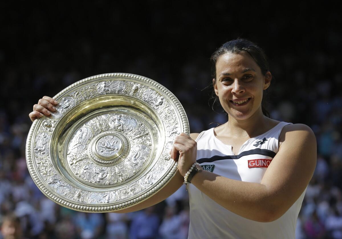 Marion Bartoli smiles with the Venus Rosewater Dish after winning the women's singles championship at Wimbledon on Saturday.