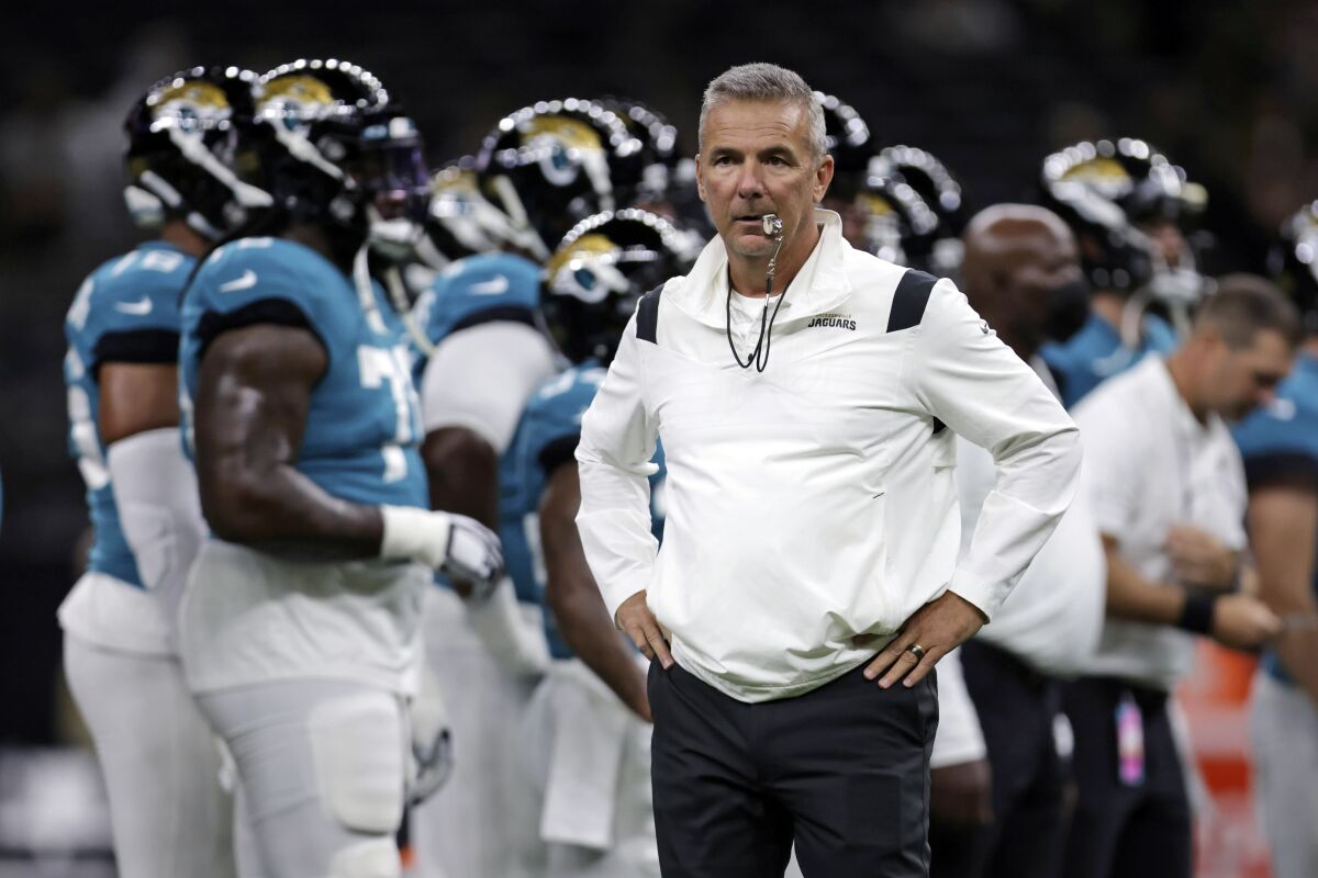 FILE - In this Monday, Aug. 23, 2021, file photo, Jacksonville Jaguars head coach Urban Meyer watches as his team warms up before a preseason NFL = football game against the New Orleans Saints in New Orleans. In many regards, Meyer runs the Jaguars like a college program It’s what he knows even though he spent a year studying the NFL before he ended a brief coaching retirement. It’s also worked at every previous stop, so no one is questioning his methods. (AP Photo/Brett Duke, File)