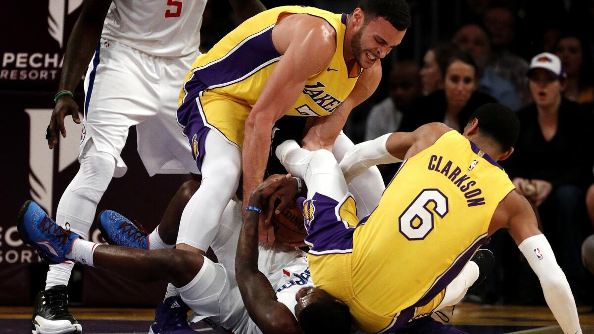 Lakers forward Larry Nance Jr. (7) and guard Jordan Clarkson force a jump ball after a scuffle with Clippers guard Jawun Evans during the second half.