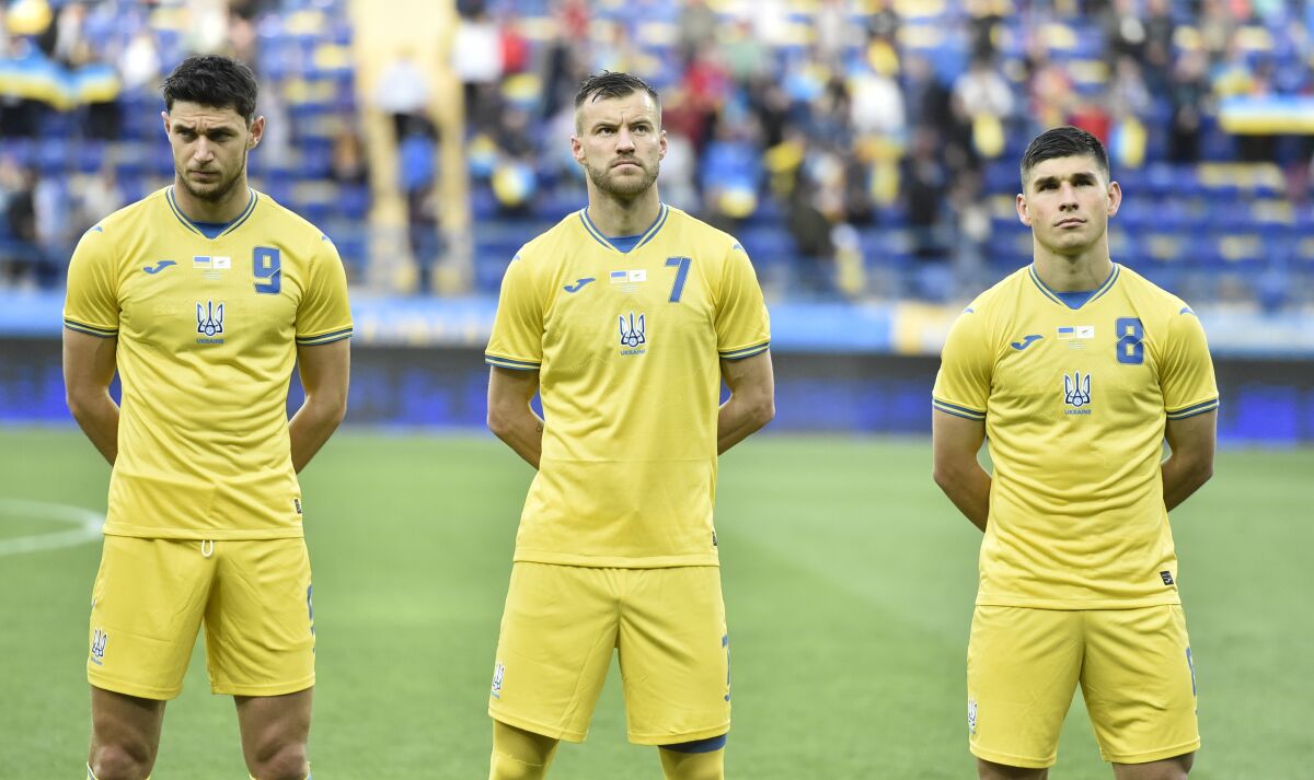 Ukraine's Roman Yaremchuk, left, Andriy Yarmolenko, center, and Ruslan Malinovskyi stand in a new kit for Ukraine's soccer team that shows a map including Russian-annexed Crimea before the international friendly soccer match between Ukraine and Cyprus in Kharkiv, Ukraine, Monday, June 7, 2021. Russian officials and lawmakers have denounced the design of the Ukrainian national soccer team's shirt for this month's European Championship. The yellow-and-blue Ukrainian uniform features a map of the country that includes Crimea and the slogan "Glory to Ukraine!". The Black Sea peninsula was annexed by Russia in 2014 following the ouster of its Moscow-friendly president. Most of the world hasn't acknowledged the annexation. (AP Photo)