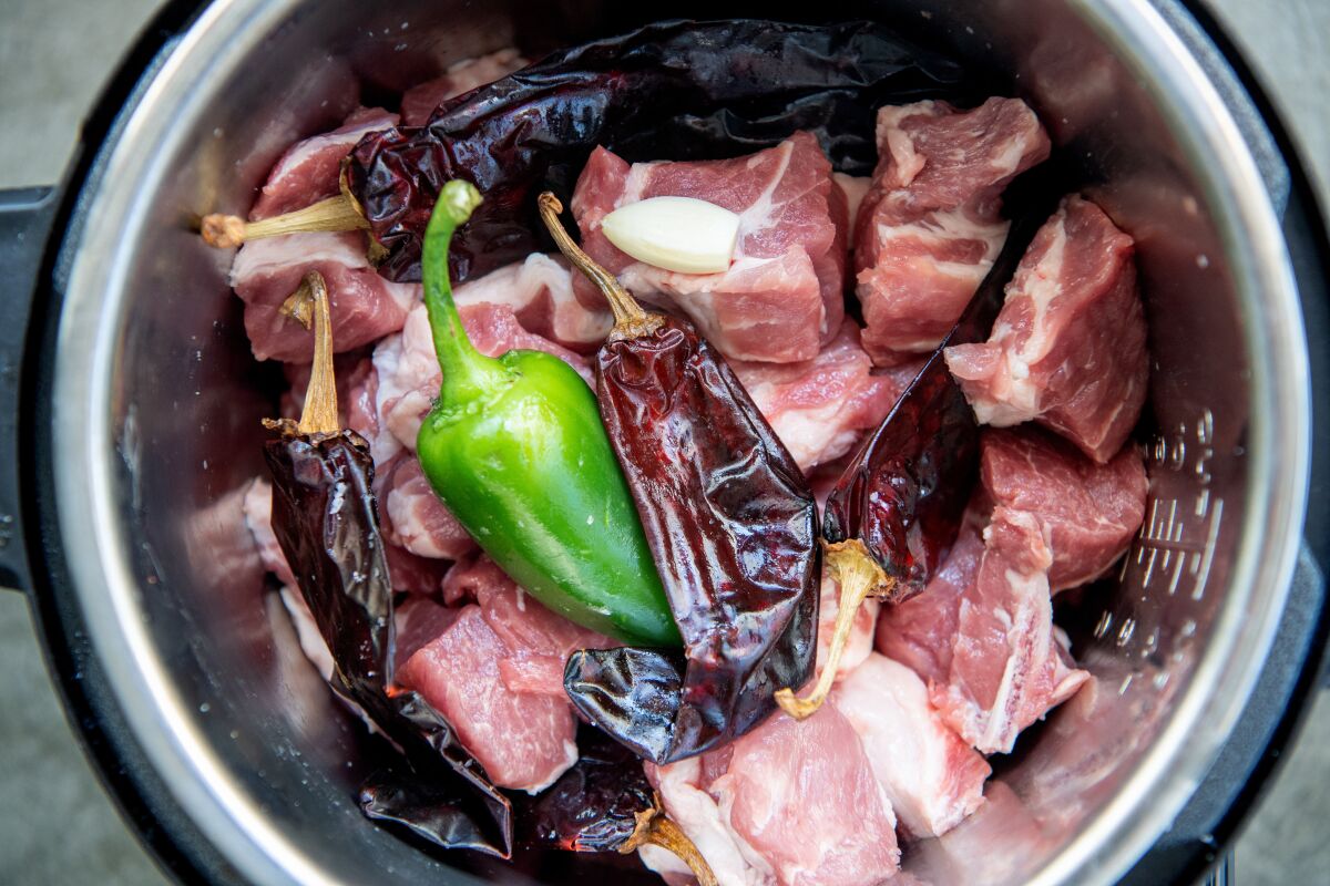 Meat with dried and fresh chiles in a pressure cooker