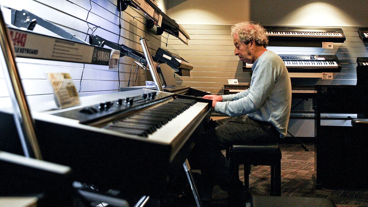 Marc Pritcher, 66, plays the piano in the keys room of the Guitar Center location in West L.A. Pritcher doesn't own a piano, but he goes to Guitar Center about five times a week to write original songs.
