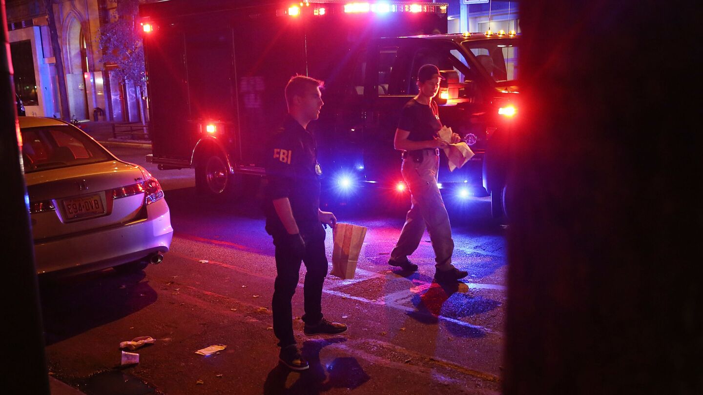 Members of the FBI search for evidence as police, firefighters and emergency workers gather at the scene of an explosion in Manhattan on on Saturday night.