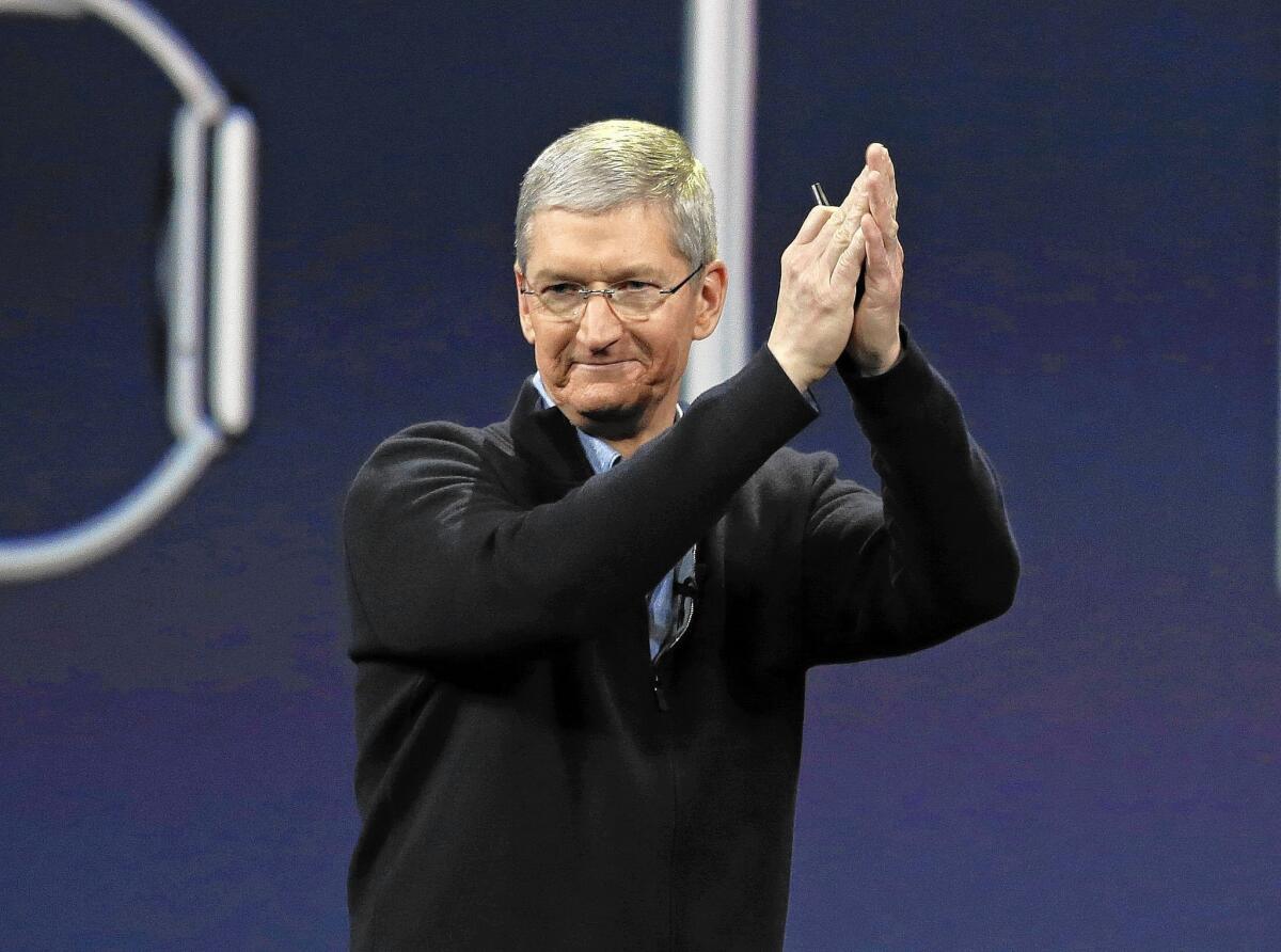 Apple CEO Tim Cook applauds at the conclusion of the Apple Watch launch event in San Francisco. Cook took a figurative victory lap at Apple's annual shareholder meeting, one day after he announced details about the new smartwatch that Apple plans to sell next month.