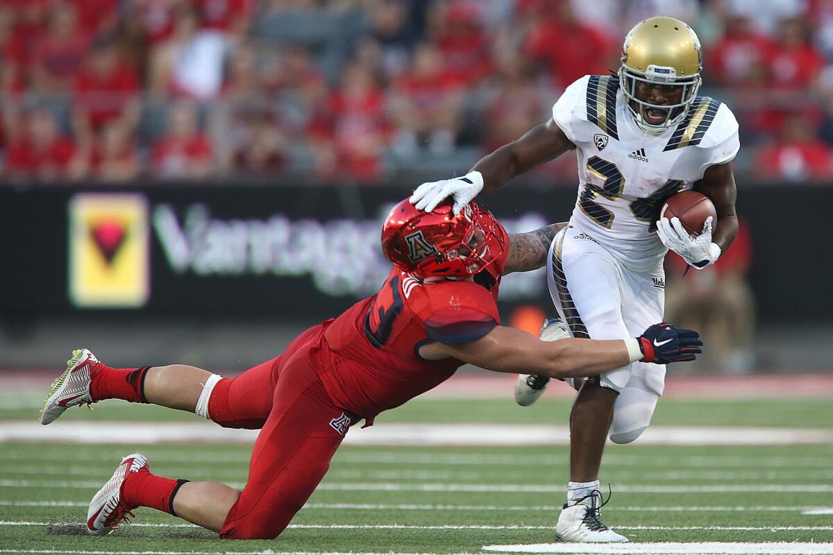 UCLA running back Paul Perkins, trying to fend off a tackle attempt by Arizona linebacker Scooby Wright III last week, ranks 10th nationally with 525 yards rushing this season.