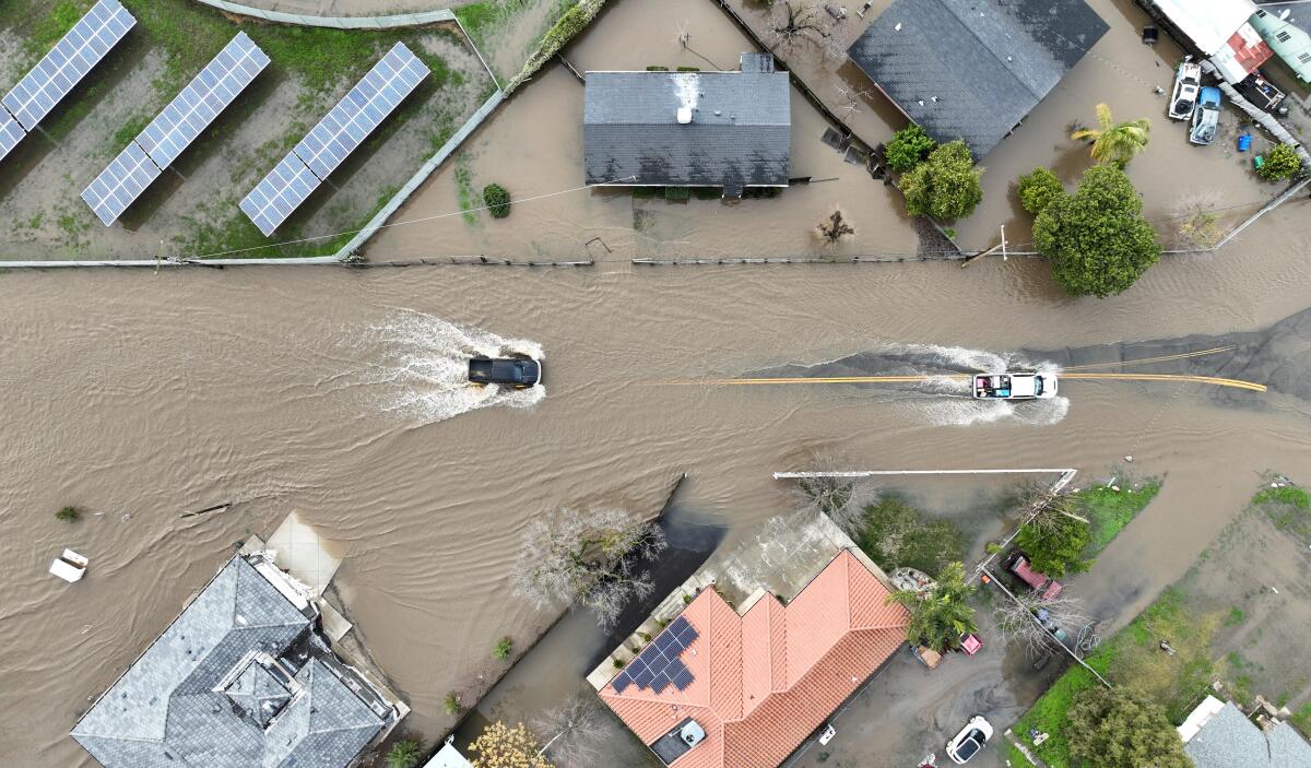Aerial view of cars driving through a flooded roadway.