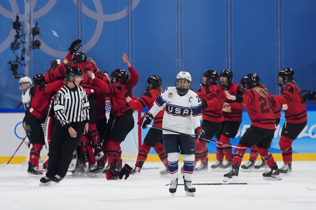 U.S.' Kendall Coyne Schofield skates away from celebrating Canadian players after the gold medal game.