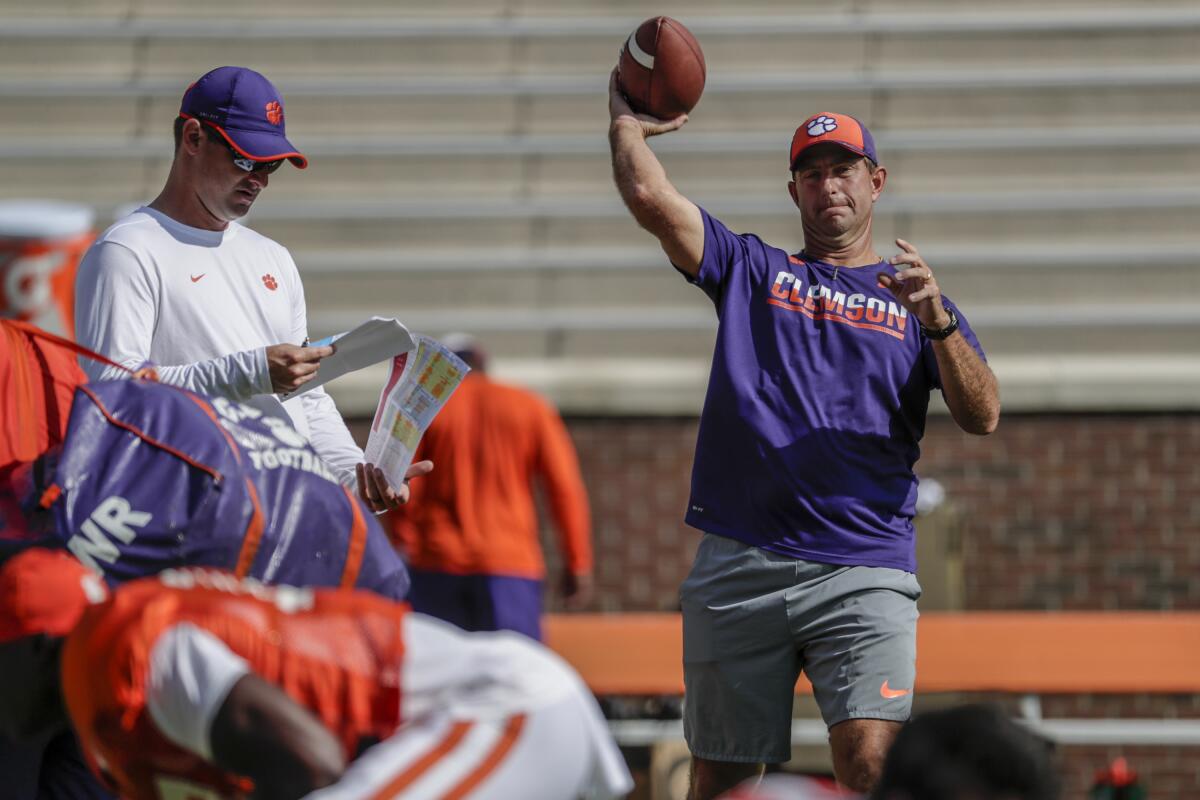 Clemson coach Dabo Swinney throws a football during a team practice session.