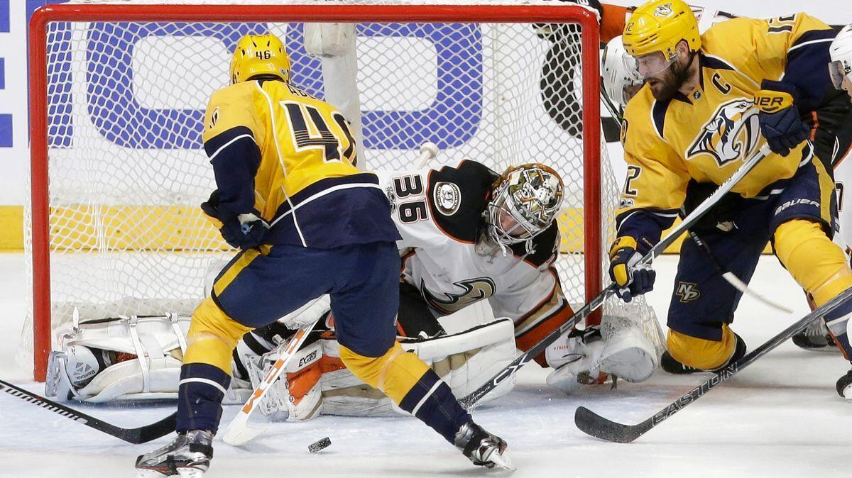 Ducks goalie John Gibson (36) blocks a shot as Nashville Predators left wing Pontus Aberg (46), and center Mike Fisher (12) watch for the rebound in Game 3 of the Stanley Cup playoffs Western Conference final, Tuesday.