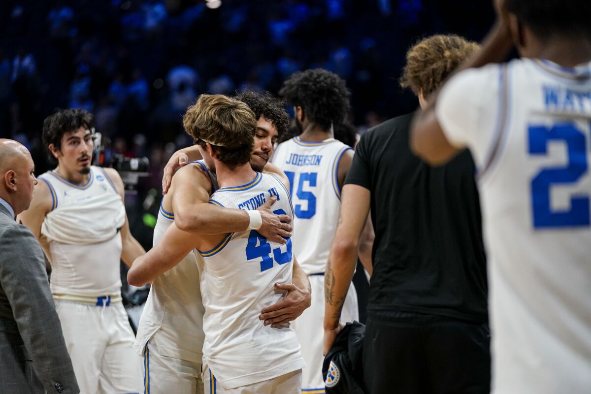 UCLA guard Jules Bernard and guard Russell Stong IV hug after the Bruins' 73-66 loss to North Carolina.