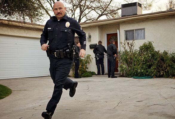 Los Angeles police officers check out a house on Newcastle Avenue that is suspected to have been a holding spot for illegal immigrants.