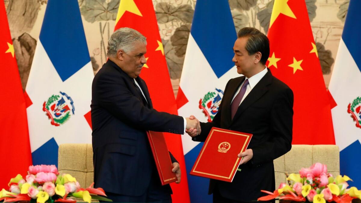 Dominican Republic Foreign Minister Miguel Vargas, left, and Chinese counterpart Wang Yi shake hands on May 1, 2018, after a signing ceremony in Beijing where they formally established diplomatic relations between the two countries.