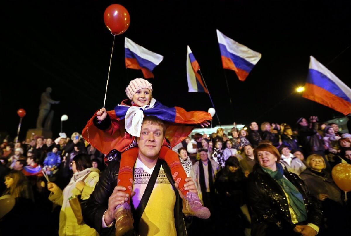 Crimeans celebrate in the central square in Simferopol, Ukraine on Friday. Russian President Vladimir signed a bill Friday making Crimea and the city of Sevastopol part of Russia.