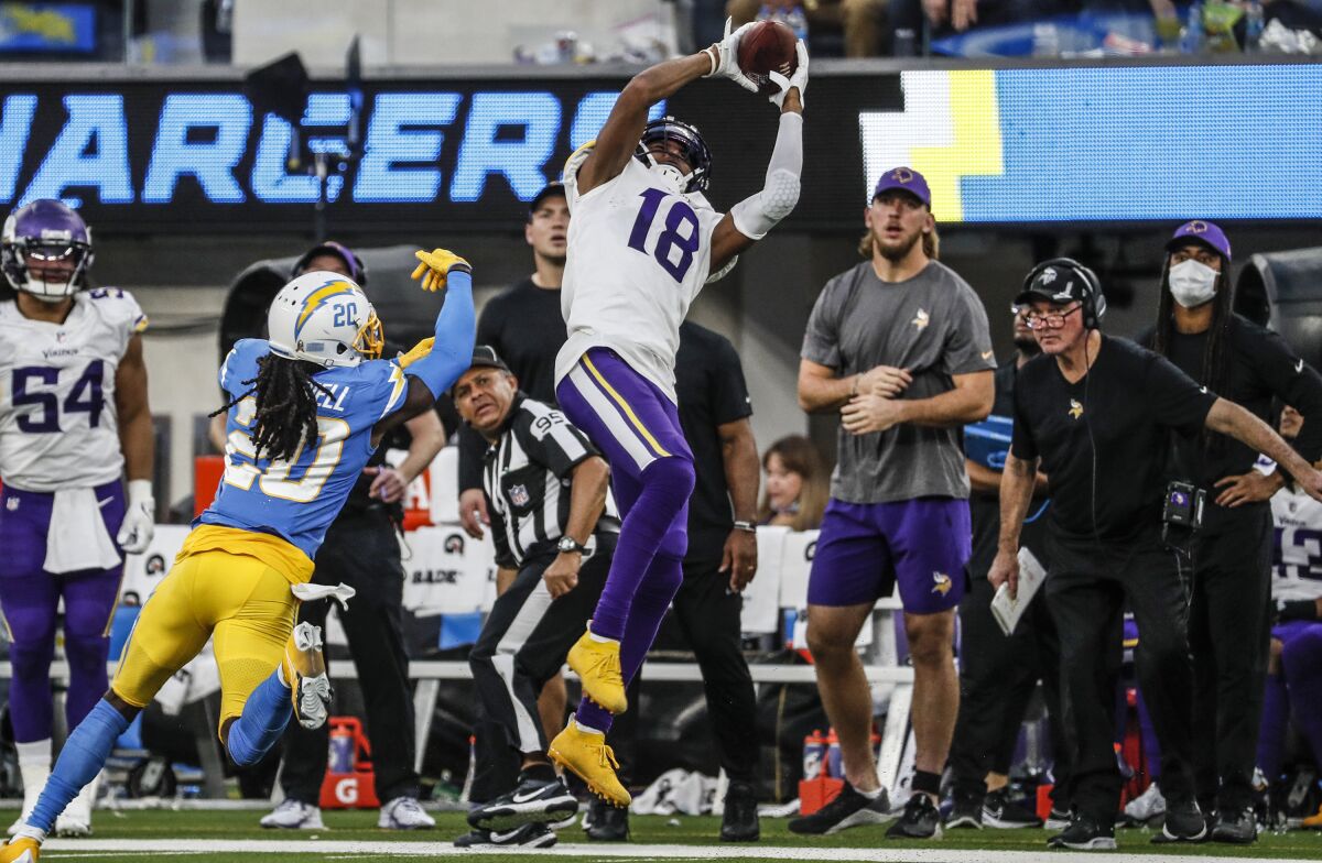 Vikings receiver Justin Jefferson (18) hauls in a 27-yard pass over the Chargers'  Tevaughn Campbell.