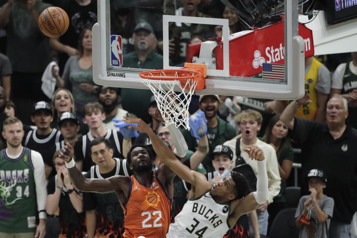Milwaukee Bucks forward Giannis Antetokounmpo (34) blocks a shot by Phoenix Suns center Deandre Ayton (22) during the second half of Game 4 of basketball's NBA Finals Wednesday, July 14, 2021, in Milwaukee. (AP Photo/Aaron Gash)