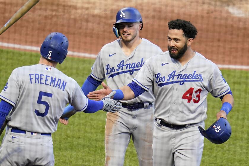 Los Angeles Dodgers' Edwin Rios (43) and Gavin Lux, center, are greeted by Freddie Freeman (5) as they return to the dugout after scoring on a double by Austin Barnes off Pittsburgh Pirates relief pitcher Anthony Banda during the third inning of a baseball game in Pittsburgh, Tuesday, May 10, 2022. (AP Photo/Gene J. Puskar)