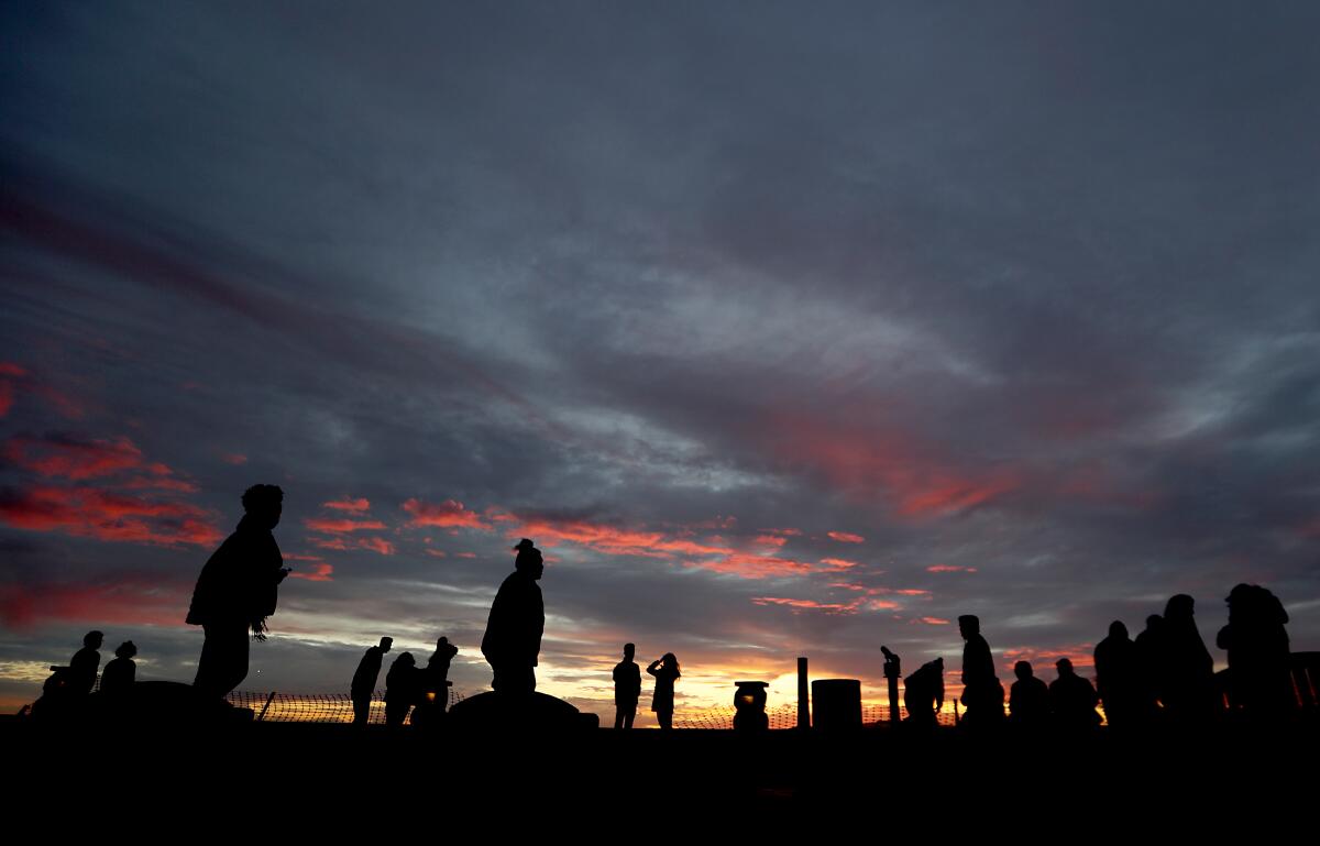 A small crowd takes in the sunset from the top of Signal Hill. 