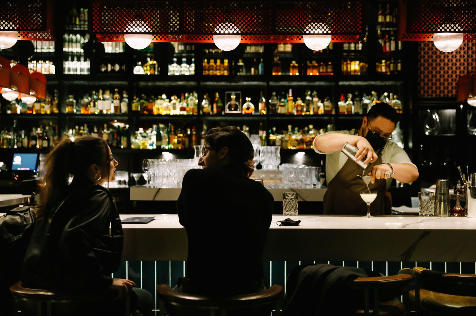 A bartender pours a drink.