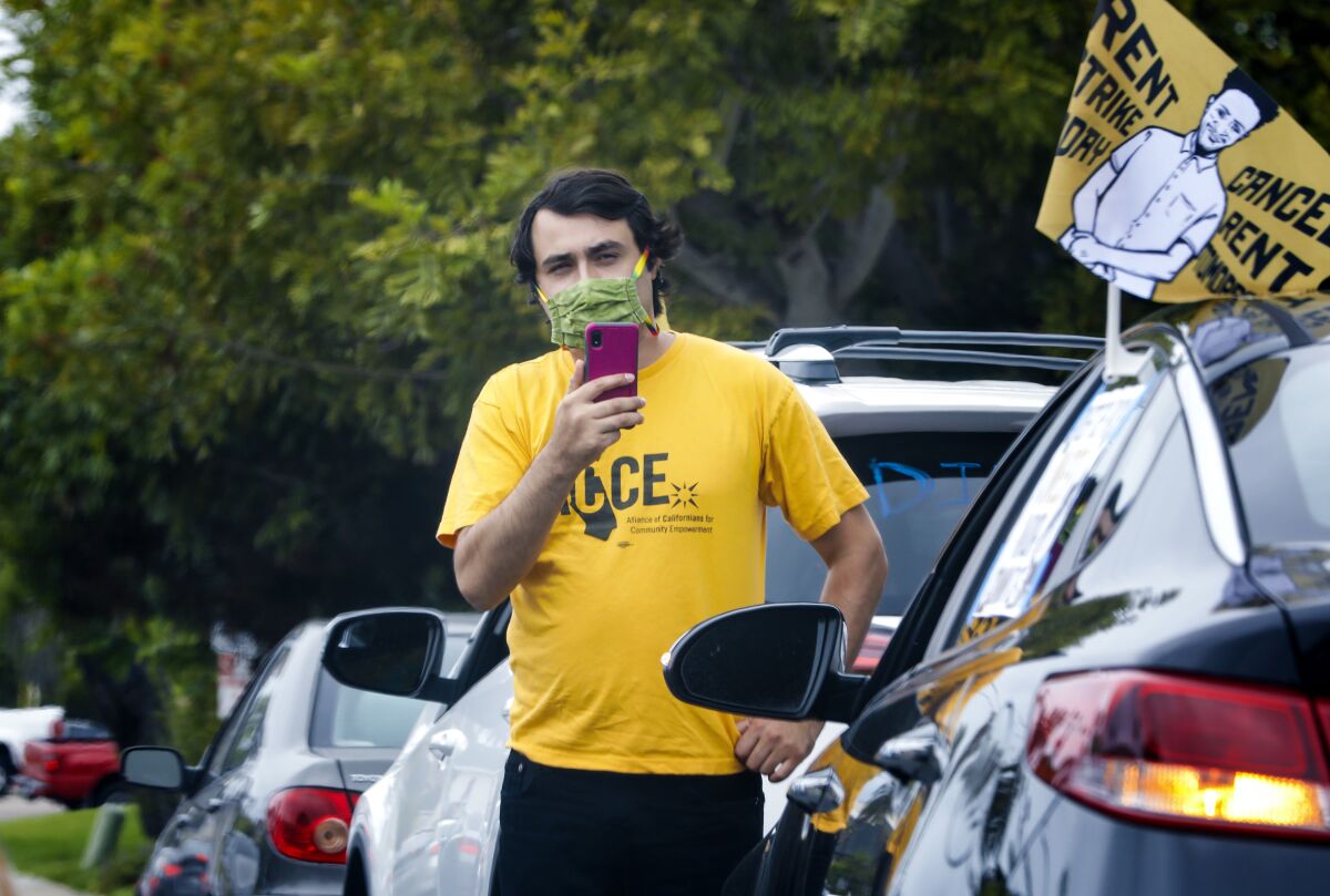 Jose Lopez of Alliance of Californians for Community Empowerment records the caravan of cars in a protest July 1 in La Jolla.