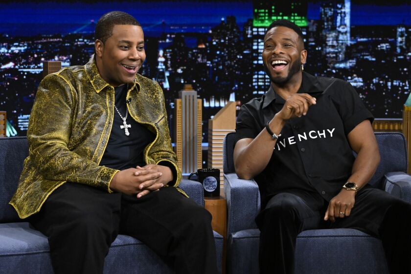 Kenan Thompson and actor Kel Mitchell seated on tonight show couches, smiling and laughing at audience 
