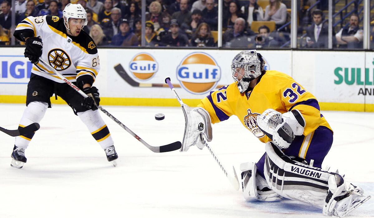 Kings goalie Jonathan Quick, right, makes a blocker save as Boston Bruins' Brad Marchand looks for the rebound during the second period of the Kings' 9-2 win over the Bruins on Feb. 9.