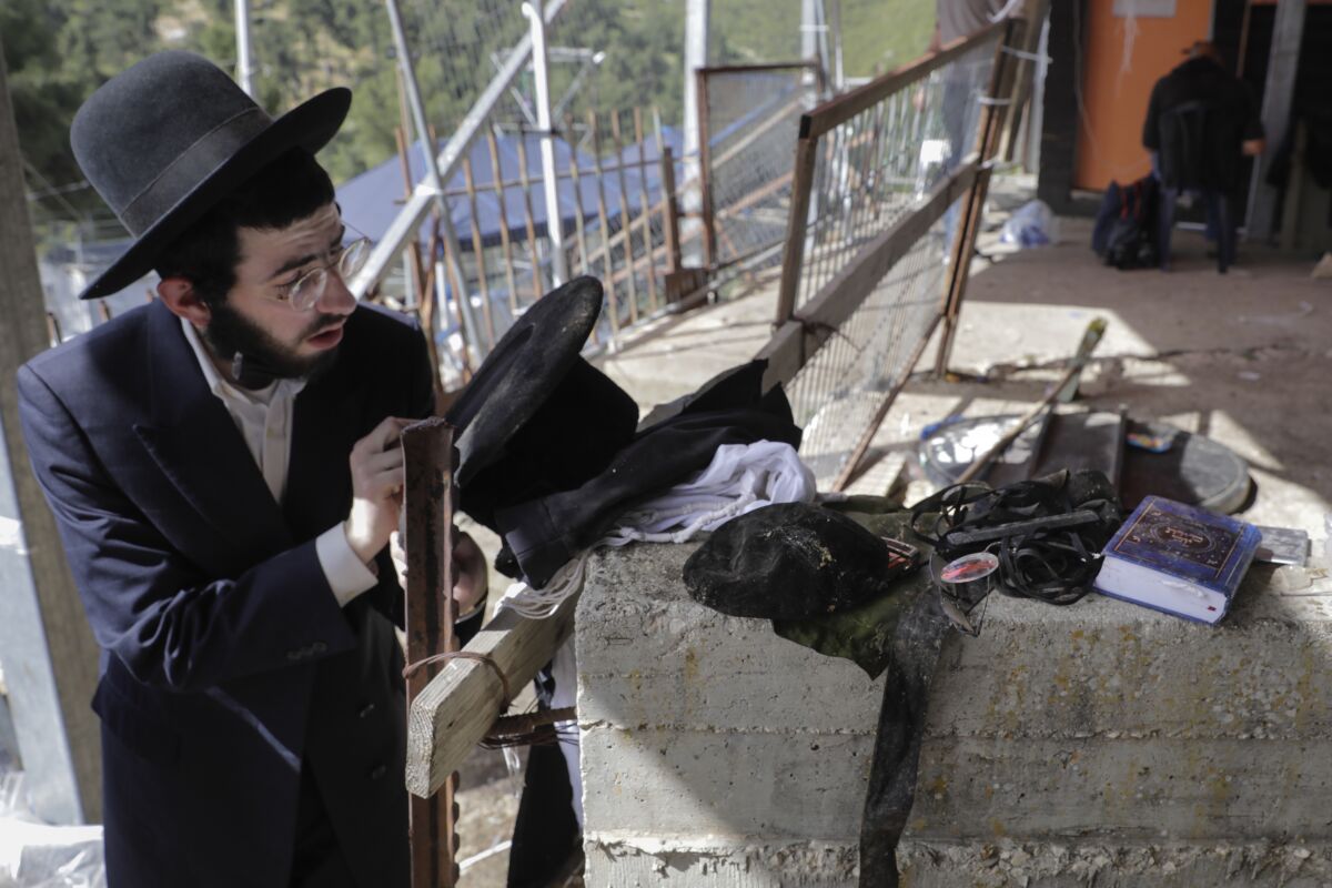 An ultra-Orthodox Jewish man stands beside a wall