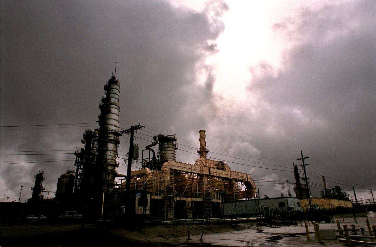 An oil refinery with storm clouds in the background