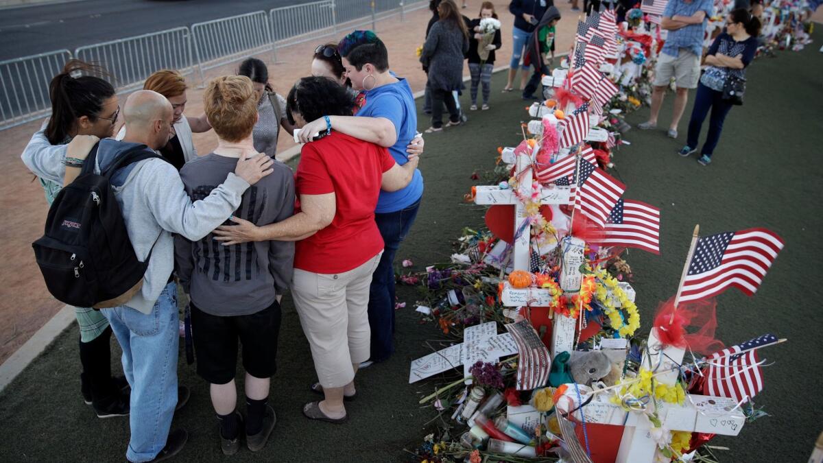 People pray at a makeshift memorial for victims of the mass shooting in Las Vegas. With no clear explanation for what prompted gunman Stephen Paddock to kill 58 concert-goers, it's difficult for the nation to move on, experts say.
