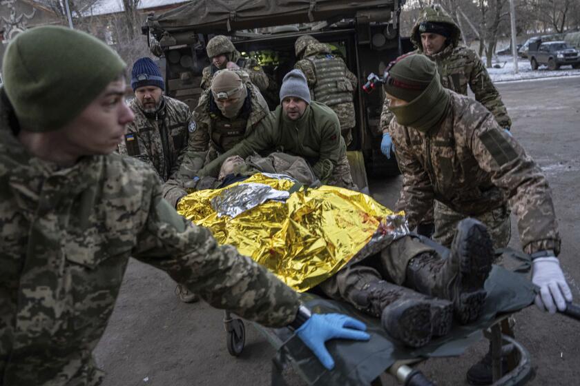 Ukrainian military medics carry an injured Ukrainian serviceman evacuated from the battlefield into a hospital in Donetsk region, Ukraine, Monday, Jan. 9, 2023. The serviceman did not survive. (AP Photo/Evgeniy Maloletka)