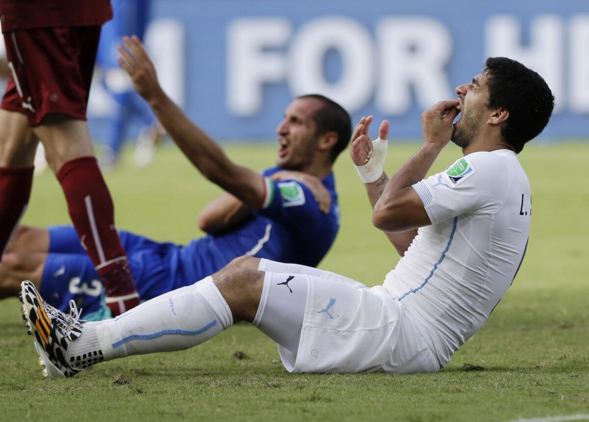 Luis Suarez, right, says he lost his balance and unintentionally bit Italy's Giorgio Chiellini on the shoulder during a World Cup match on Tuesday.