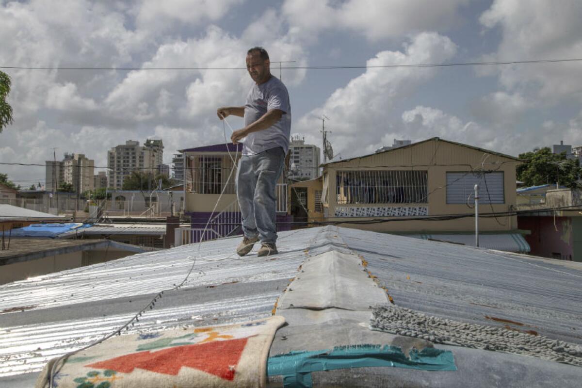 Jorge Ortiz works to tie down his roof Aug. 27 as he prepares for the arrival of Hurricane Dorian in San Juan, Puerto Rico.
