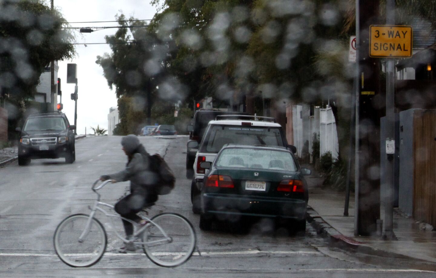 A bicyclist makes her way along Main Street during Tuesday morning rain in Venice.