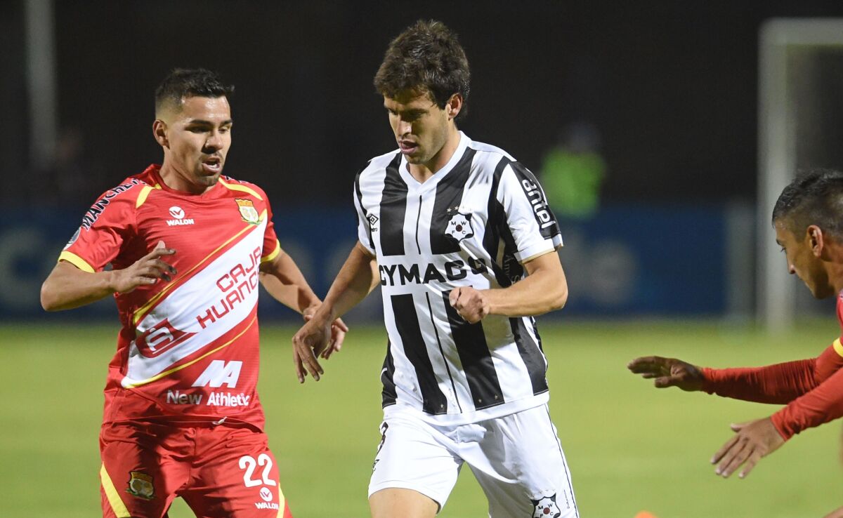 Montevideo Wanderers midfielder Francisco Ginella, center, controls the ball during a Copa Sudamericana match in Peru in April.