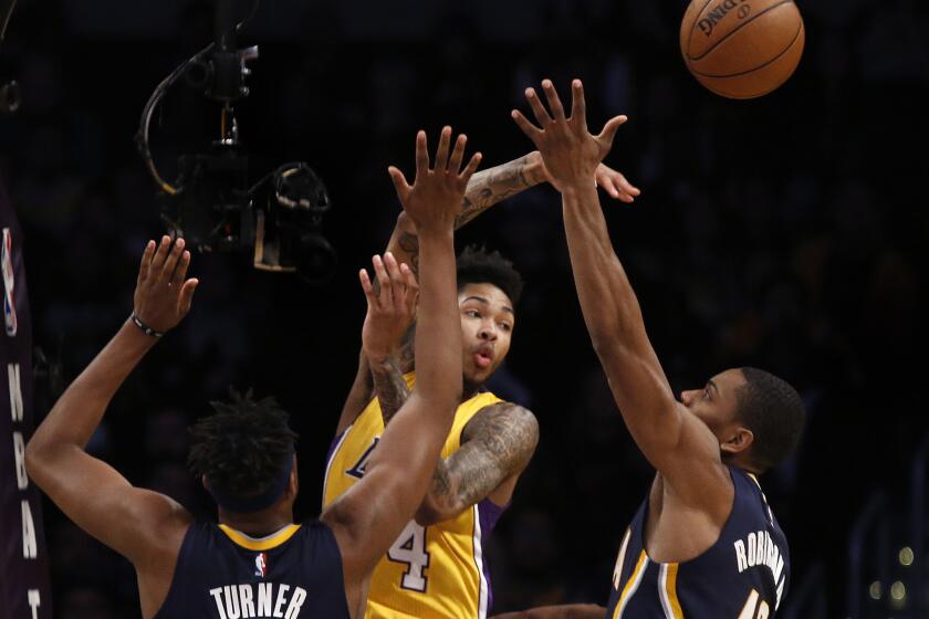Lakers forward Brandon Ingram passes the ball away from pressure by Pacers center Myles Turner, left, and guard Glenn Robinson during the first half on Jan. 20.