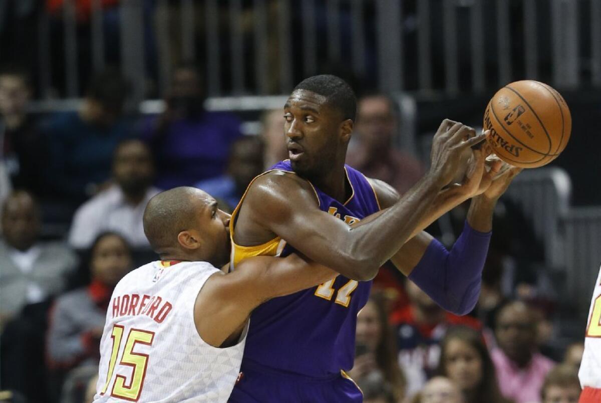 Atlanta forward Al Horford pokes the ball away from Lakers center Roy Hibbert during the first half of a game Dec. 4 in Atlanta.