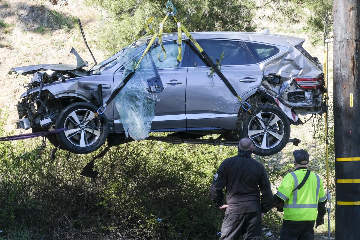 FILE - In this Feb. 23, 2021, file photo, a crane is used to lift a vehicle following a rollover accident involving golfer Tiger Woods, in the Rancho Palos Verdes suburb of Los Angeles. The Los Angeles County sheriff plans to announce Wednesday, April 7, 2021, what caused Woods to crash an SUV in Southern California earlier in the year, seriously injuring himself in the wreck. (AP Photo/Ringo H.W. Chiu, File)