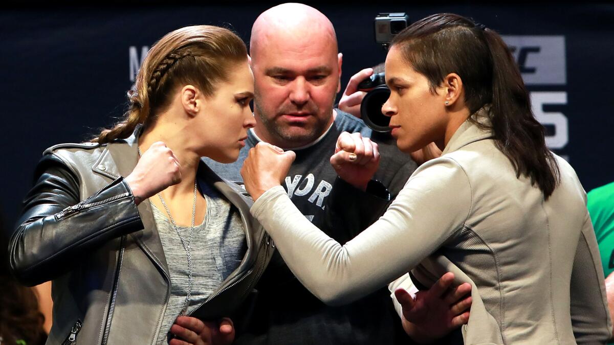 Ronda Rousey, left, and Amanda Nunes strike a familiar pose alongside UFC President Dana White on Friday in New York to promote their Dec. 30 fight.