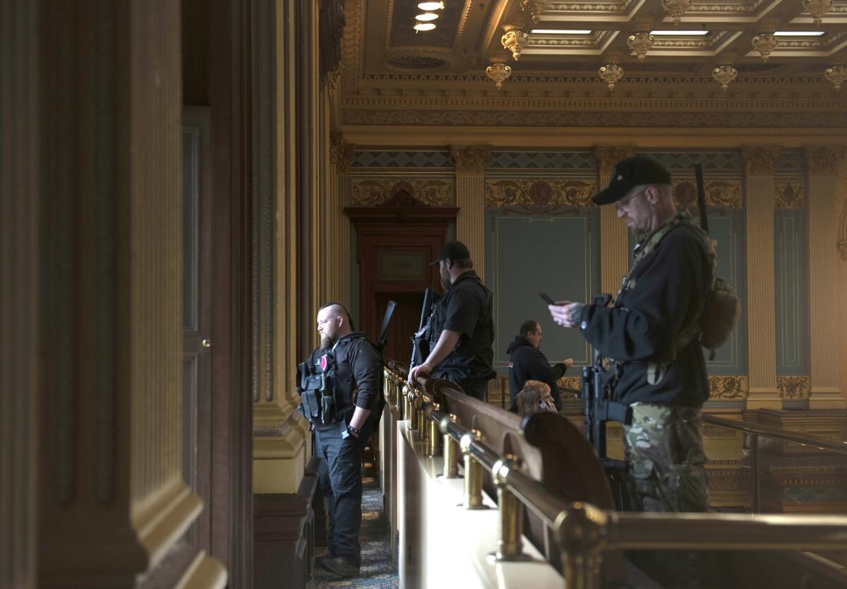 Armed militia members stand around.