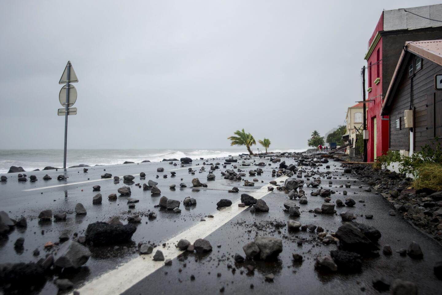 Rocks swept up by hurricane-generated waves cover a road along the oceanfront in Le Carbet, on the French Caribbean island of Martinique.